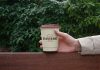 Free Hand Holding Small Paper Coffee Cup Mockup PSD