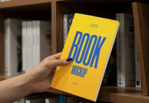 Free Hand Holding Thin Book Title Mockup PSD